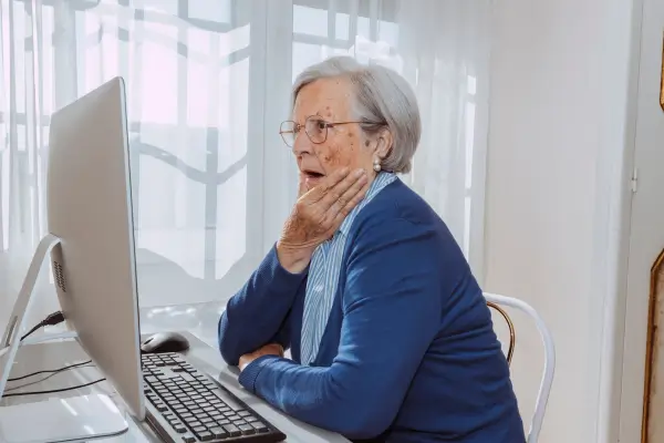 Idosa usando tecnologia na leitura